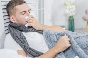 Person mit Erkältung putzt sich die Nase